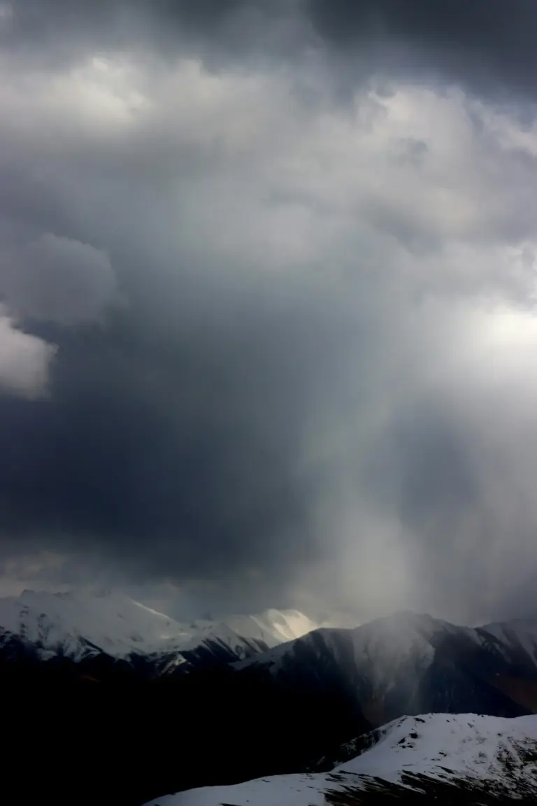 Storm clouds over snow-capped mountains